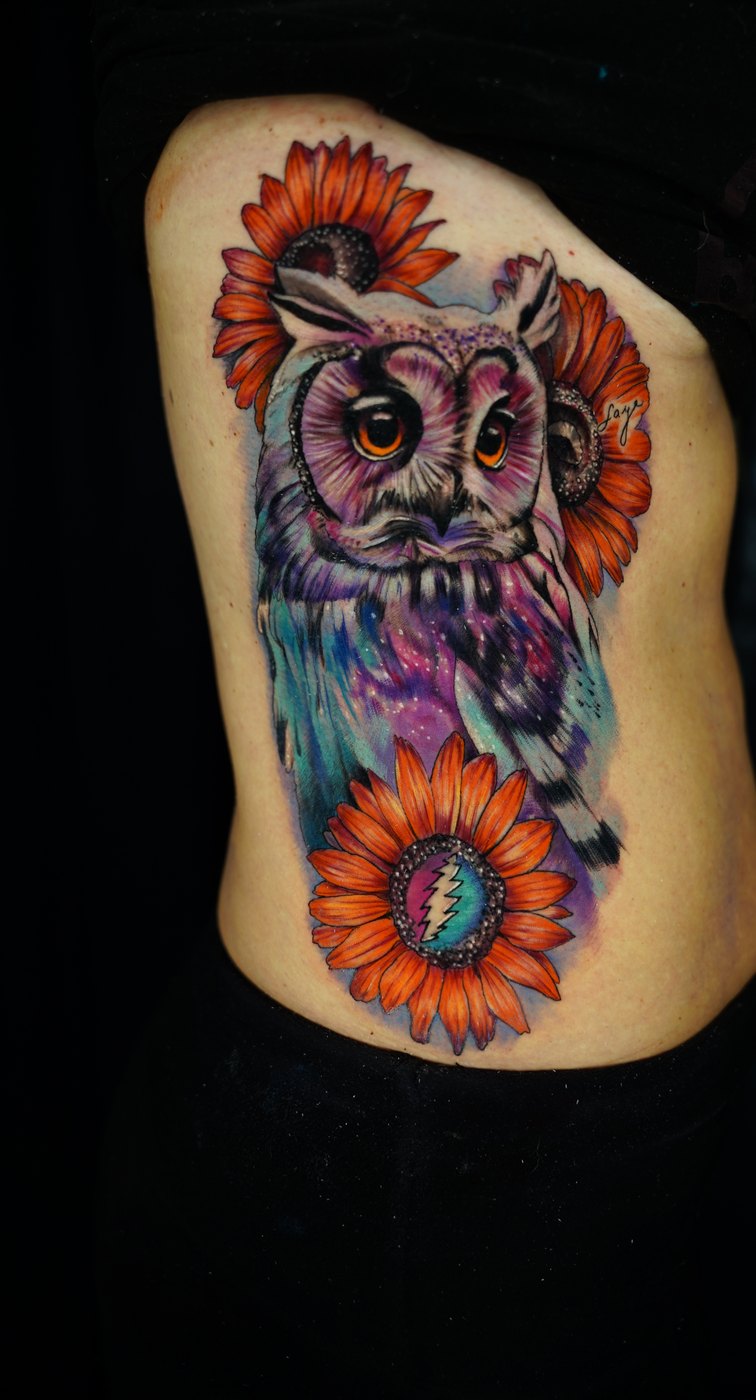Cosmic owl and sunflowers color rib tattoo by Bubba Irwin, Grateful Dead inspired